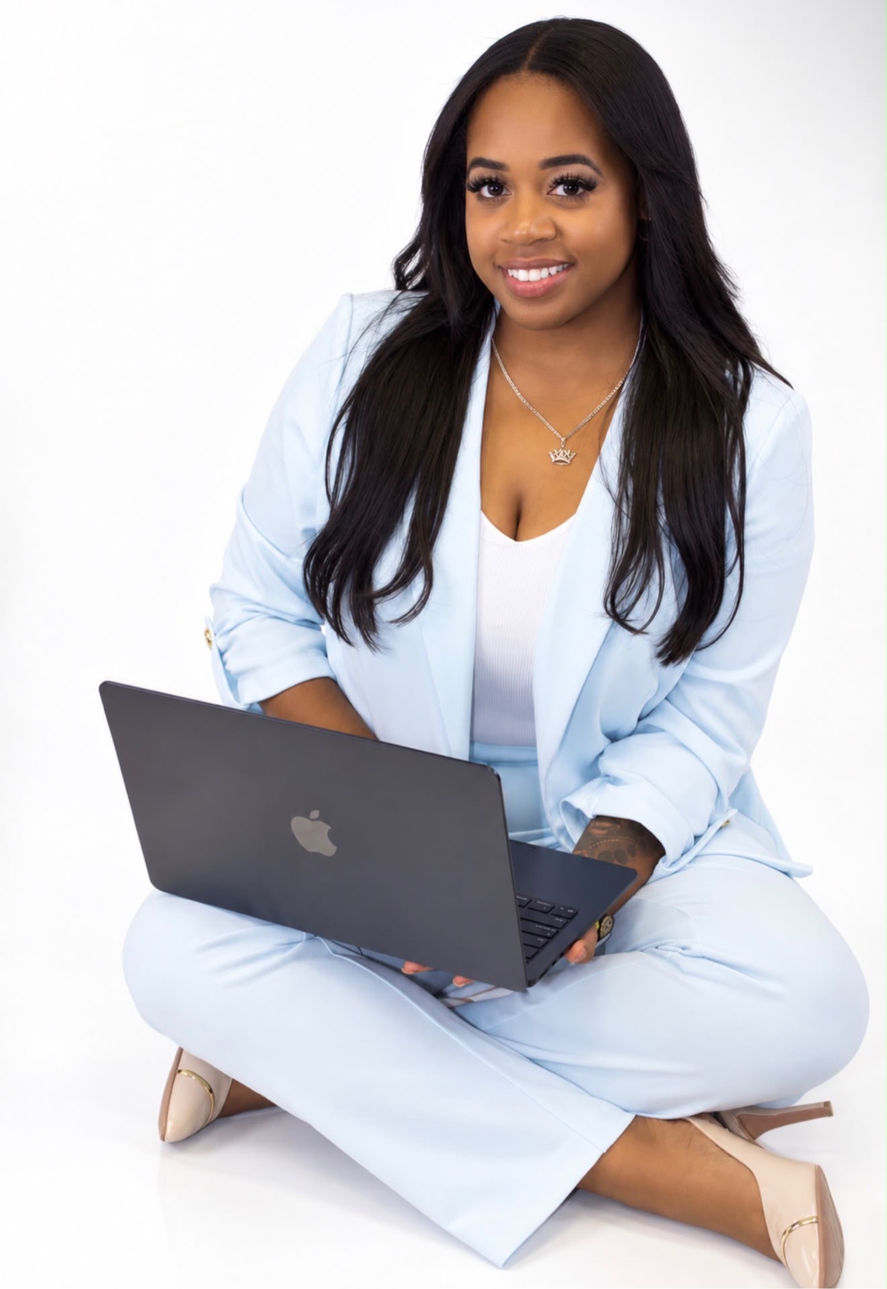 Owner of Cisneros Multi-Services smiling with a laptop